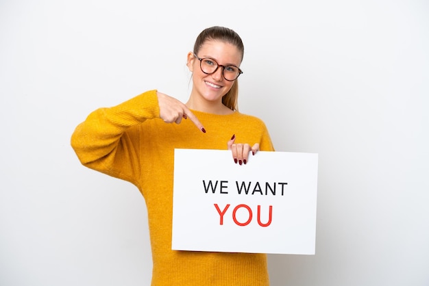 Photo young caucasian woman isolated on white background holding we want you board and pointing it