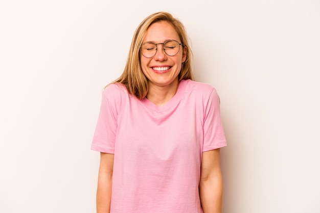 Young caucasian woman isolated on white background laughs and closes eyes feels relaxed and happy