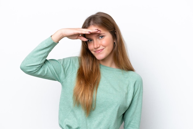 Young caucasian woman isolated on white background looking far away with hand to look something