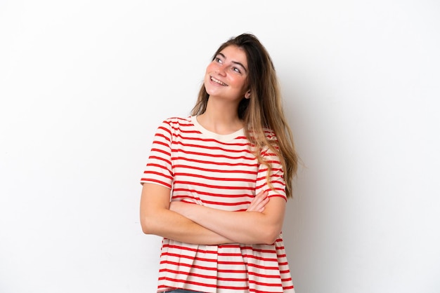 Photo young caucasian woman isolated on white background looking up while smiling