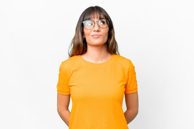 Photo young caucasian woman over isolated white background and looking up