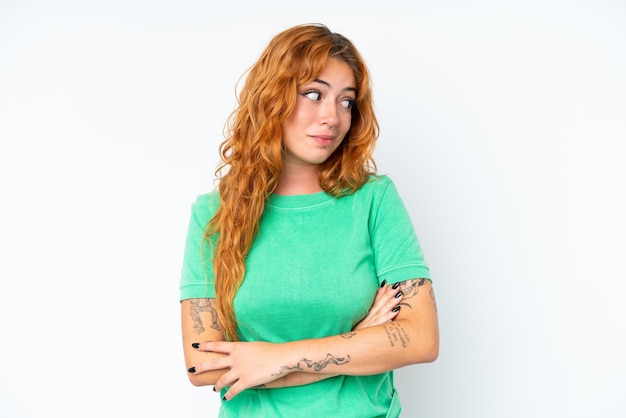 Young caucasian woman isolated on white background making doubts gesture looking side