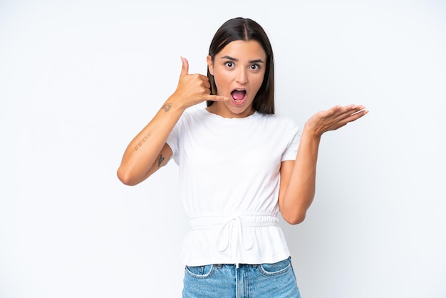 Young caucasian woman isolated on white background making phone gesture and doubting