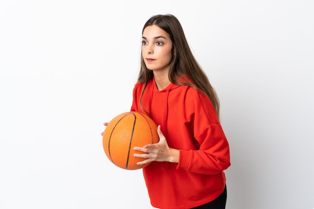 Young caucasian woman isolated on white background playing basketball