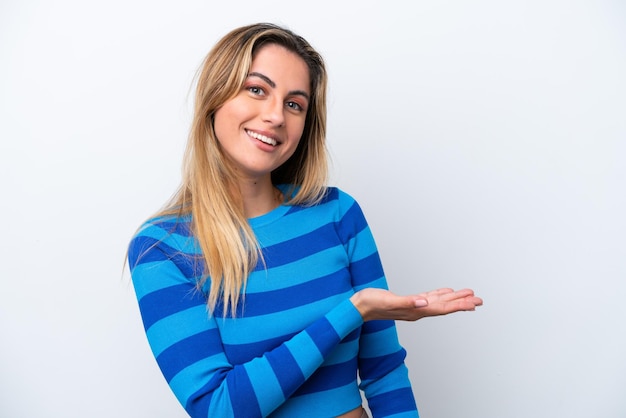 Young caucasian woman isolated on white background presenting an idea while looking smiling towards