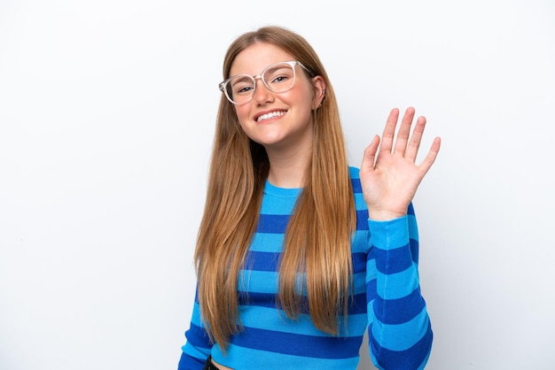 Young caucasian woman isolated on white background saluting with hand with happy expression