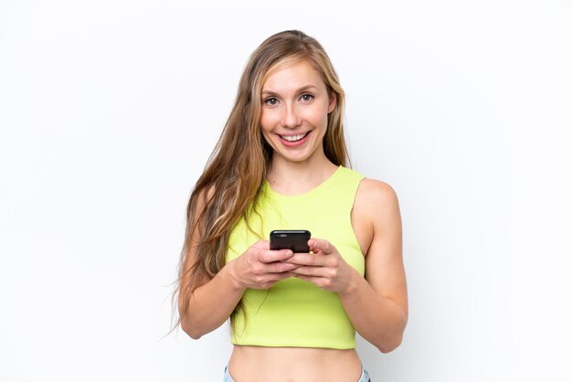 Young caucasian woman isolated on white background sending a message with the mobile