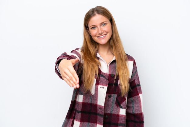 Young caucasian woman isolated on white background shaking hands for closing a good deal