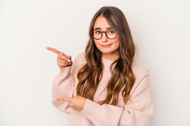 Young caucasian woman isolated on white background shocked pointing with index fingers to a copy space.