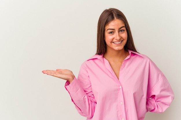 Young caucasian woman isolated on white background showing a copy space on a palm and holding another hand on waist.