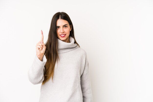 Young caucasian woman isolated on a white background showing number one with finger.