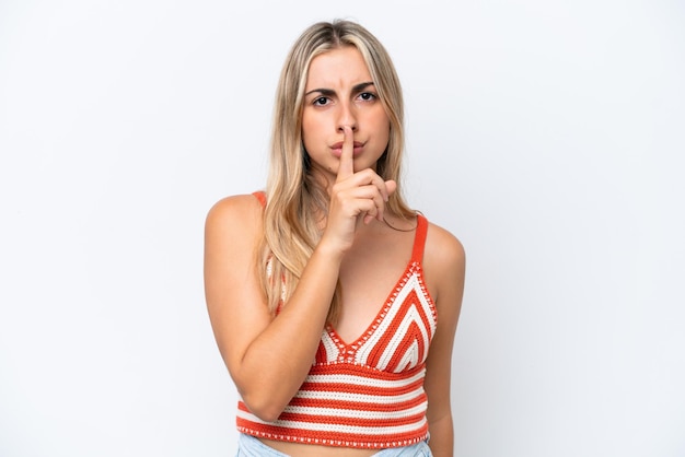 Young caucasian woman isolated on white background showing a sign of silence gesture putting finger in mouth