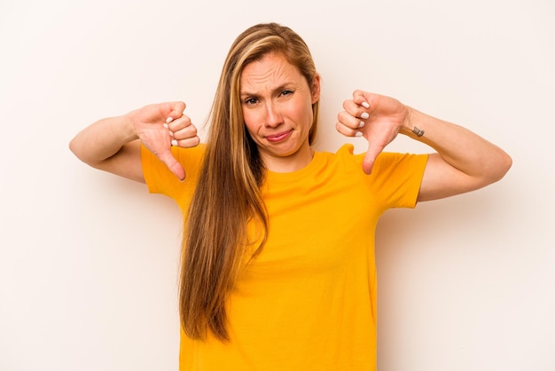 Young caucasian woman isolated on white background showing thumb down disappointment concept