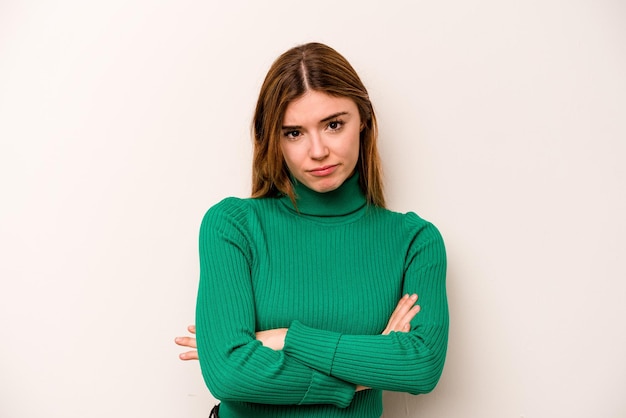 Young caucasian woman isolated on white background suspicious uncertain examining you