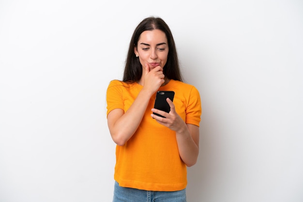 Young caucasian woman isolated on white background thinking and sending a message