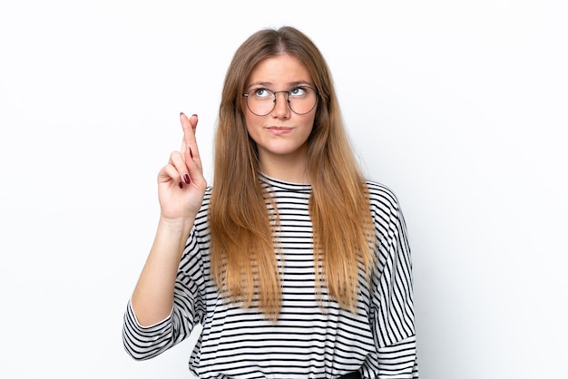 Young caucasian woman isolated on white background with fingers crossing and wishing the best