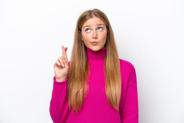 Young caucasian woman isolated on white background with fingers crossing and wishing the best