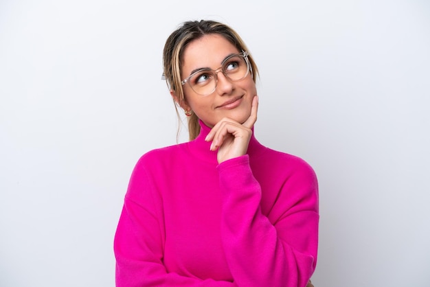 Young caucasian woman isolated on white background With glasses and thinking while looking up