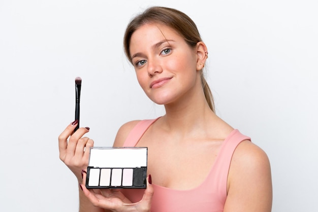 Young caucasian woman isolated on white background with makeup palette