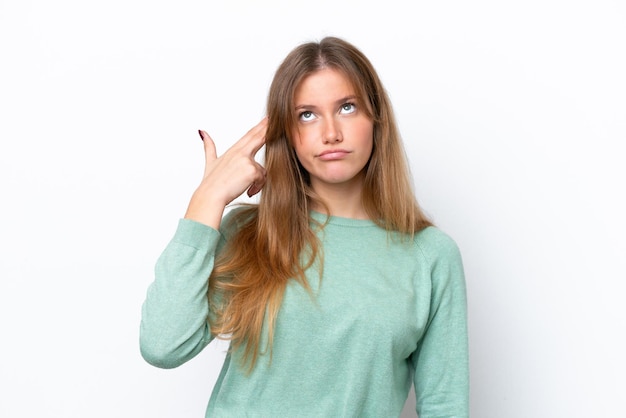 Young caucasian woman isolated on white background with problems making suicide gesture