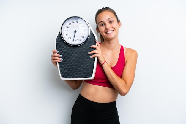 Young caucasian woman isolated on white background with weighing machine