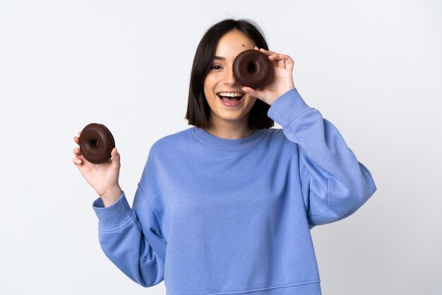 Young caucasian woman isolated on white holding a donut and happy