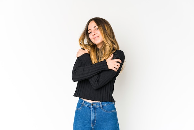 Young caucasian woman isolated on white hugs, smiling carefree and happy.