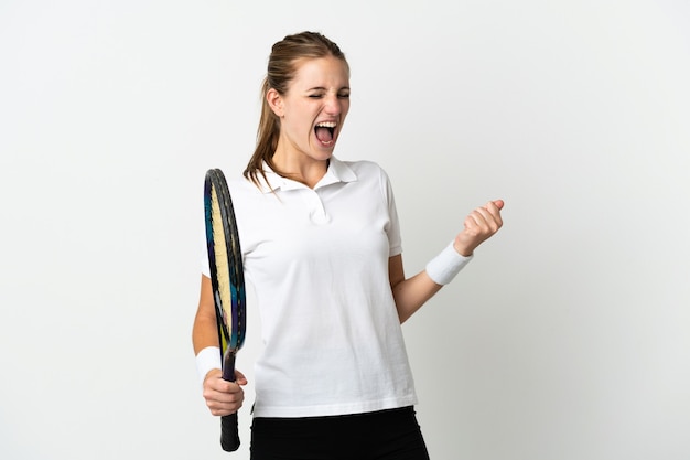 Young caucasian woman isolated on white wall playing tennis and celebrating a victory