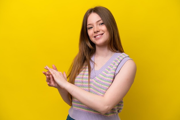 Young caucasian woman isolated on yellow background applauding