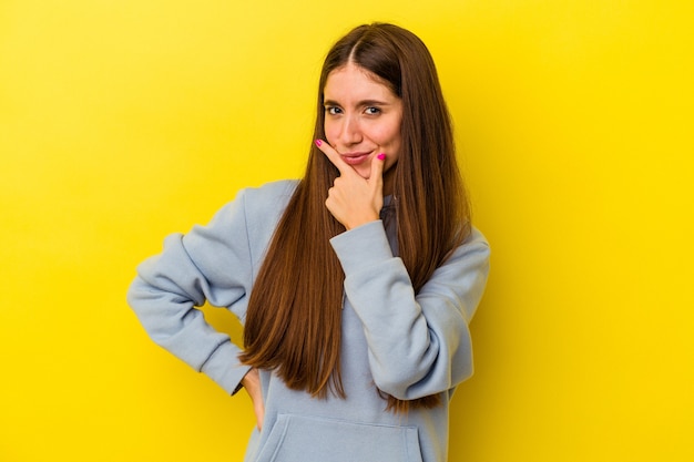 Young caucasian woman isolated on yellow background contemplating, planning a strategy, thinking about the way of a business.