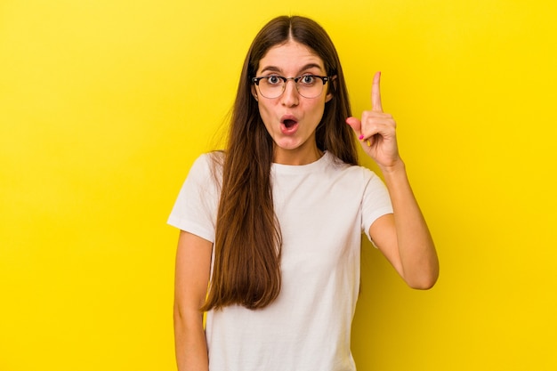 Young caucasian woman isolated on yellow background having an idea, inspiration concept.