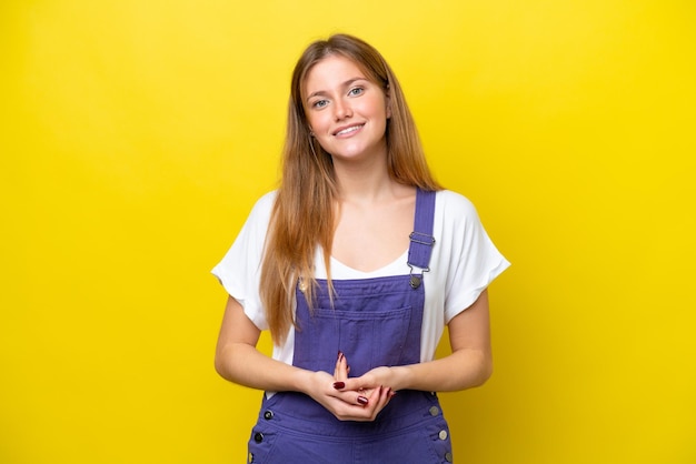 Young caucasian woman isolated on yellow background laughing