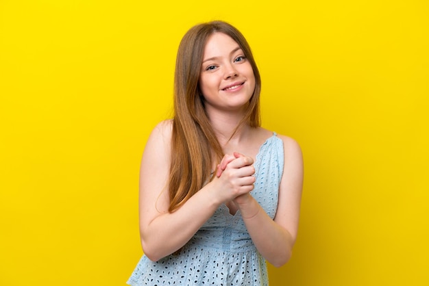 Young caucasian woman isolated on yellow background laughing