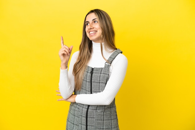 Young caucasian woman isolated on yellow background pointing up a great idea