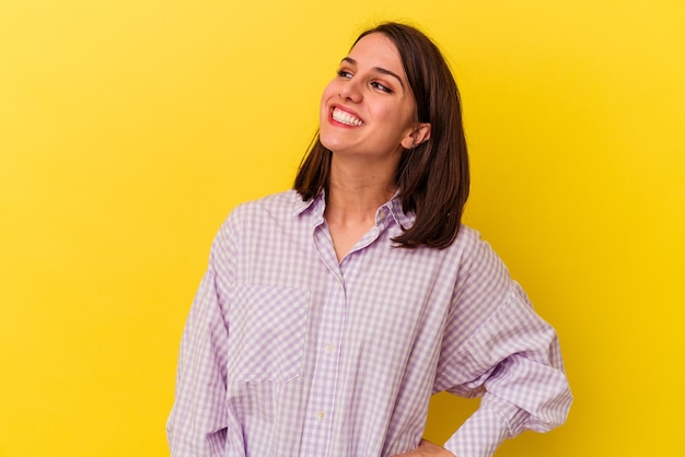 Young caucasian woman isolated on yellow background relaxed and happy laughing, neck stretched showing teeth.