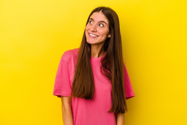 Young caucasian woman isolated on yellow background relaxed and happy laughing, neck stretched showing teeth.