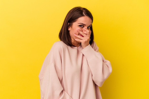 Young caucasian woman isolated on yellow background scared and afraid