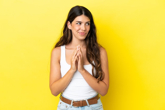 Young caucasian woman isolated on yellow background scheming something