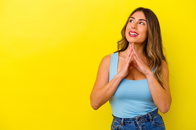 Young caucasian woman isolated on yellow background