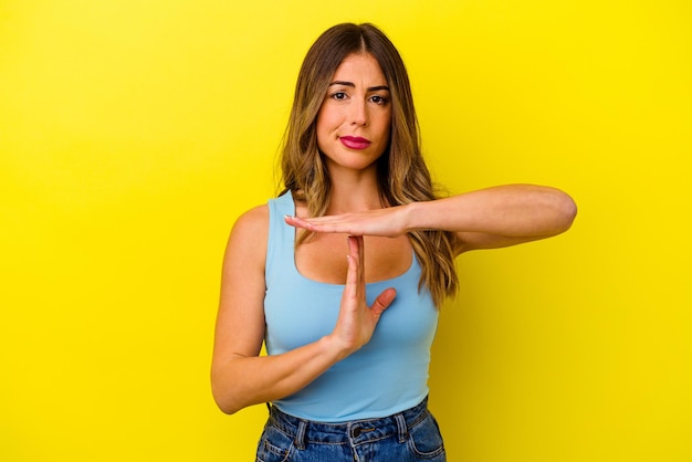 Young caucasian woman isolated on yellow background