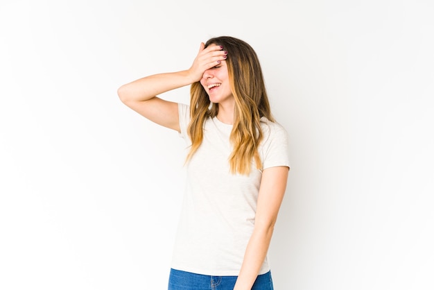 Young caucasian woman laughs joyfully keeping hands on head. Happiness concept.