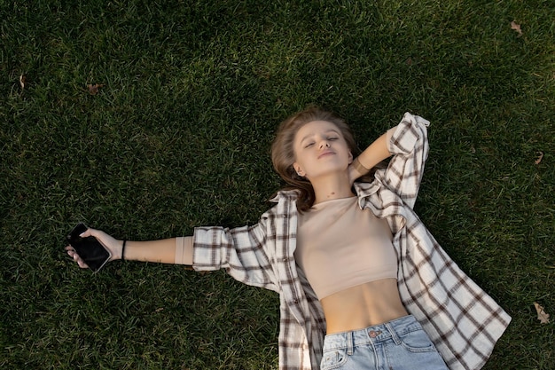 Young caucasian woman lies on green grass