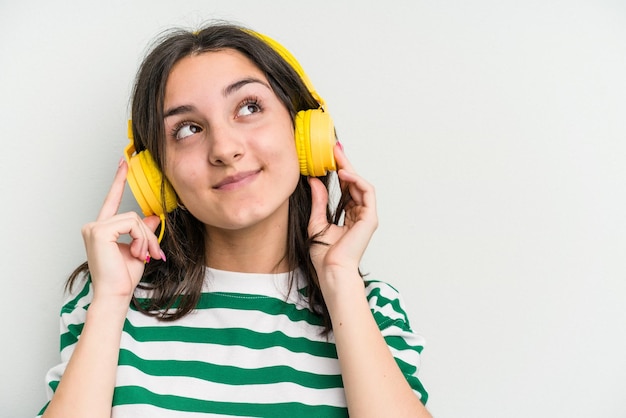 Young caucasian woman listening to music isolated on white background