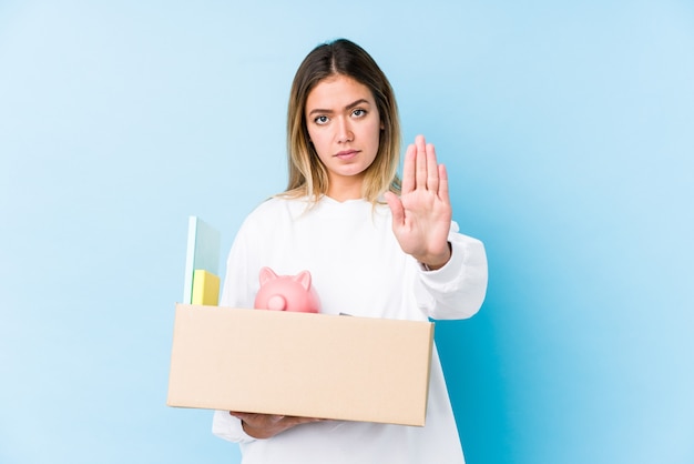 Young caucasian woman moving home isolated standing with outstretched hand showing stop sign, preventing you.