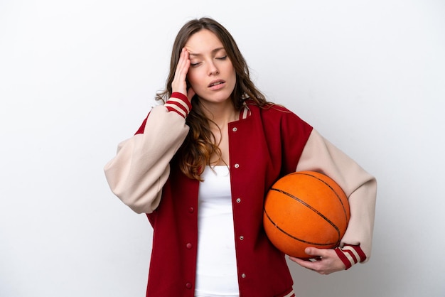 Young caucasian woman playing basketball isolated on white background with headache