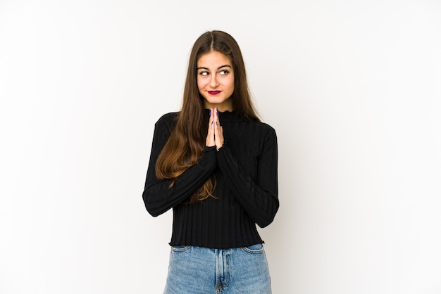 Young caucasian woman praying, showing devotion, religious person looking for divine inspiration.