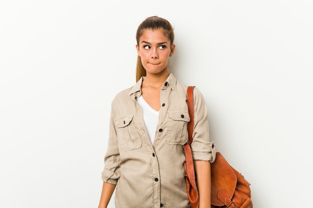 Young caucasian woman ready for a travel feeling confused