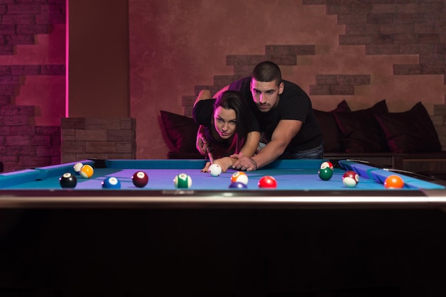 Young Caucasian Woman Receiving Advice On Shooting Pool Ball While Playing Billiards