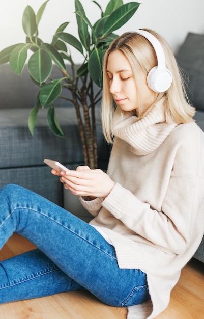 Young caucasian woman relaxes at home with music