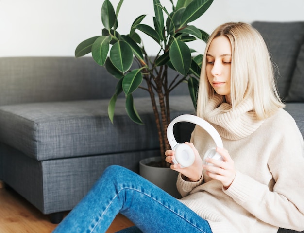 Young caucasian woman relaxes at home with music